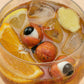 Glass of iced tea with fruit and gummy eyeballs on a light background