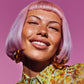 Woman with pink hair and floral shirt against a pink background