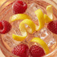 Glass of pink lemonade with raspberries and lemon slices on a light background