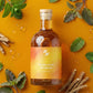 Bottle of 'Stress Less Tincture' with herbs on an orange background